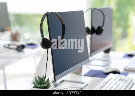 Computer monitor with empty space for your design and VOIP headset on desk at modern office Stock Photo