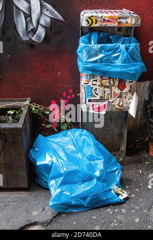 Small artwork, pink girl with stars next to sticker covered garbage can at Haus Schwarzenberg,39 Rosenthaler Strasse, Mitte, Berlin. Stock Photo