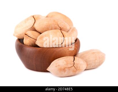 Pecan nuts in wooden bowl, isolated on white background. Unshelled pecan. Stock Photo