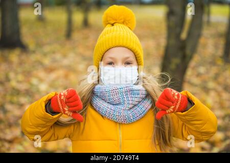 blond Girl wearing respirator mask in autumn Stock Photo
