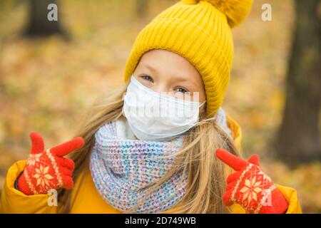 blond Girl wearing respirator mask in autumn Stock Photo