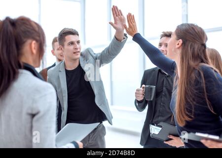 young employees giving each other a high five Stock Photo