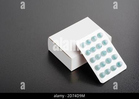 Pillbox with a loaf of tablets on dark background, editable mock-up series template ready for your design, selection path included. Stock Photo