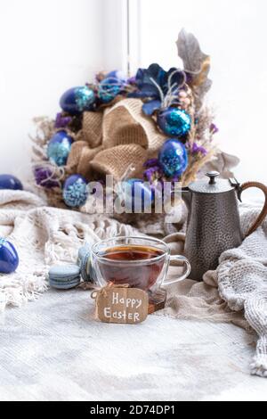 Cozy Easter, spring still life scene. Breakfast with tea and dessert macaroons .The concept of the Easter holidays and decor. Stock Photo