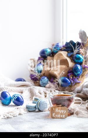 Cozy Easter, spring still life scene. Breakfast with tea and dessert macaroons .The concept of the Easter holidays and decor. Stock Photo