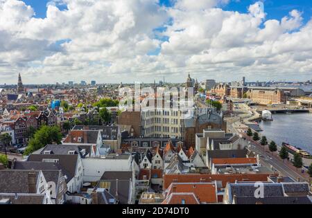 Beautiful View over Amsterdam Rooftops and Cityscape from Aerial perspective next to Oosterdok with Blue Sky and big clouds Stock Photo