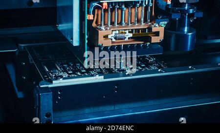 Close-up Macro Shot of Electronic Printed Circuit Board Being Assembled with Automated Robotic Arm, Surface Mounted Technology Connecting Microchips Stock Photo