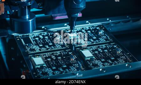 Macro Close-up Shot of Printed Circuit Board on a Factory Assembly Line with Automated Robotic Arm for Surface Mounting Microprocessors to the Stock Photo