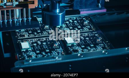 Macro Close-up Shot of Printed Circuit Board on a Factory Assembly Line with Automated Robotic Arm for Surface Mounting Microprocessors to the Stock Photo
