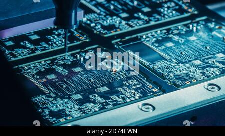 Macro Close-up Shot of Printed Circuit Board on a Factory Assembly Line with Automated Robotic Arm for Surface Mounting Microprocessors to the Stock Photo