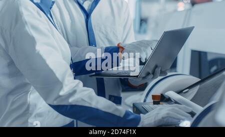 Close-up Shot of an Engineers Hands On High Tech Factory Using Computer for Programming Pick and Place Electronic Machinery for Printed Circuit Board Stock Photo