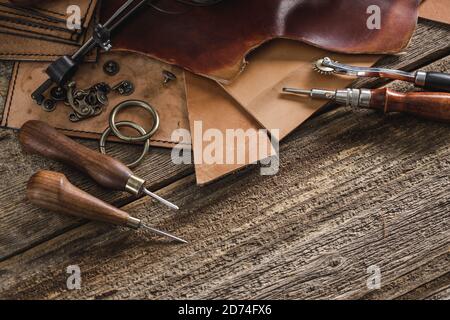 Antique leatherworking tools on a wooden table on Craiyon