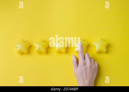 The concept of assessment. The client's hand gives a four star rating. Rating services, the concept of satisfaction Stock Photo