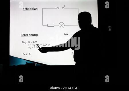 Bannewitz, Germany. 07th Oct, 2020. A teacher is standing at a digital blackboard in a classroom of a secondary school at Marienschacht in Bannewitz near Dresden in Saxony. On the board, tasks for the subject physics are displayed, which pupils have to solve. Credit: Daniel Schäfer/dpa-Zentralbild/ZB/dpa/Alamy Live News Stock Photo