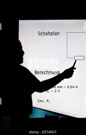 Bannewitz, Germany. 07th Oct, 2020. A teacher is standing at a digital blackboard in a classroom of a secondary school at Marienschacht in Bannewitz near Dresden in Saxony. On the board, tasks for the subject physics are displayed, which pupils have to solve. Credit: Daniel Schäfer/dpa-Zentralbild/ZB/dpa/Alamy Live News Stock Photo