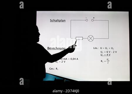 Bannewitz, Germany. 07th Oct, 2020. A teacher is standing at a digital blackboard in a classroom of a secondary school at Marienschacht in Bannewitz near Dresden in Saxony. On the board, tasks for the subject physics are displayed, which pupils have to solve. Credit: Daniel Schäfer/dpa-Zentralbild/ZB/dpa/Alamy Live News Stock Photo