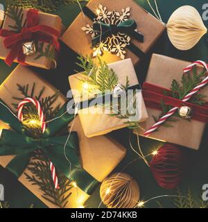 Many Christmas gift boxes tied velvet ribbons with paper decorations in garland lights. Stock Photo