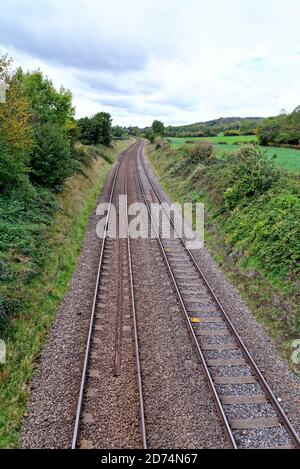 Empty railway track receding into countryside in the Surrey Hills, near Abinger Hammer England UK Stock Photo