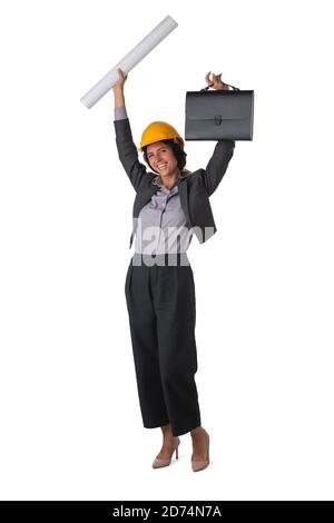 Portrait of female engeneer architect in yellow hardhat and business suit with raised arms isolated on white background full length studio portrait Stock Photo