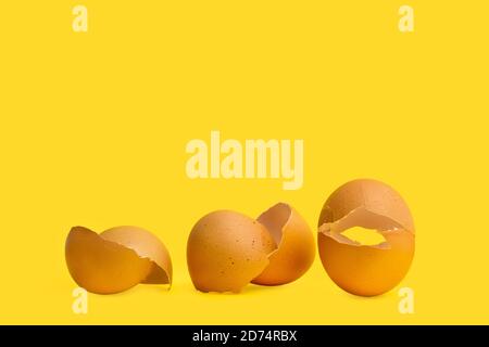 Cracked eggshells on a yellow background in a close up view Stock Photo