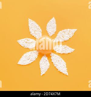 Flower made of yolk and cracked egg shell in abstract style on soft yellow background. Organic meal concept. Abstract background. Mockup for your design. Flat lay style. Stock Photo