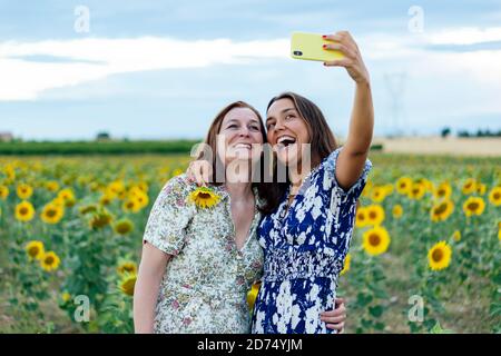 mother and daughter hugging taking a picture with the smartphone Stock Photo
