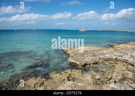 Frederiksted, St. Croix, US Virgin Islands-January 4,2020: Rocky shore and sailboats in the blue Caribbean Sea waters on the island of St. Croix Stock Photo