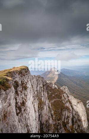 Impressive view of Trem summit on Suva planina, Serbia, Sokolov kamen ane Mosor peaks in the background, dramatic sky and autumn colors of the forest Stock Photo