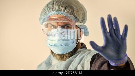 Dangerous zone. Stop. Personal protective equipment. Man wearing protective mask. Coronavirus pandemic. Garments protect health. Infection prevention. Face protection goggles mask head cover. Stock Photo