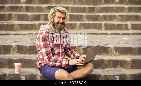 bearded man sit on stairs with laptop. online distant education. inspired to work with coffee. agile business. mature student working on computer. go shopping on cyber monday. Confident graduate. Stock Photo
