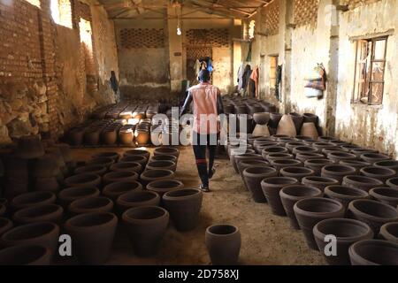 Khartoum, Sudan. 20th Oct, 2020. A Sudanese potter walks past clay pots in Khartoum, Sudan, on Oct. 20, 2020. Sudanese potters use the clay left by the floods to make clay pots. Credit: Mohamed Khidir/Xinhua/Alamy Live News Stock Photo