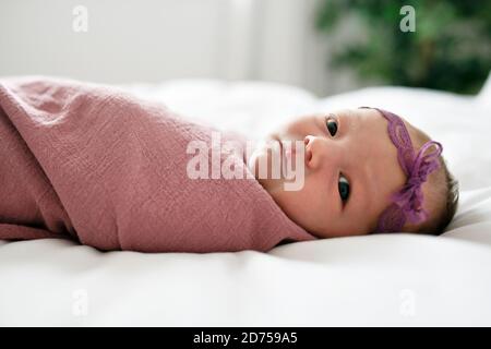 Cute newborn baby girl on the white bed Stock Photo