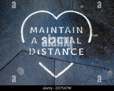 Covid-19 Pavement Signs - Coronavirus Pandemic Pavement Signs - Stylised Maintain A Social Distance message signs in London's Soho. Stock Photo