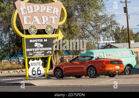 Seligman USA - September 29 2015; Typical Route 66 retro style sign for Copper Cart with modern Mustang parked below and old VW Kombi Stock Photo