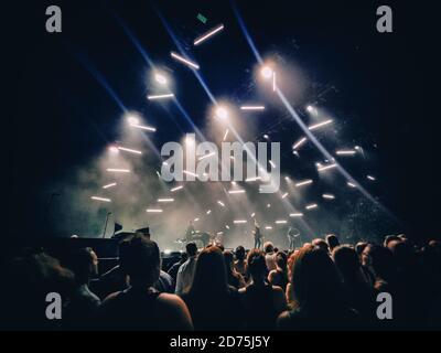 Concert show background with crowd silhouettes listening to acoustic guitar music live performance by rock band on stage. Dark with lights. Mobile Stock Photo