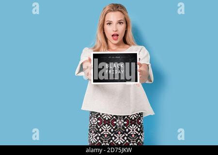 Young blonde hold tablet with black friday banner on the screen Stock Photo