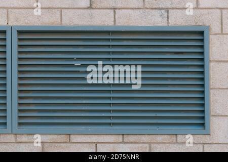 Close-up view of fragment modern industrial building facade and ventilation grille. Outdoor ventilation grille on the wall of a building. Square metal Stock Photo