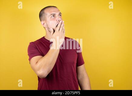 Russian man wearing basic red t-shirt over yellow insolated background afraid and shocked with surprise expression, fear and excited face. Stock Photo