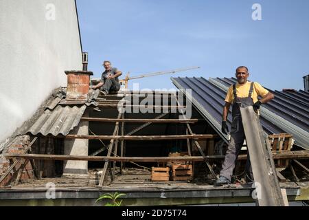Two workers roofer builder working on roof structure on construction site Stock Photo