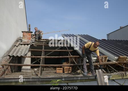 Two workers roofer builder working on roof structure on construction site Stock Photo