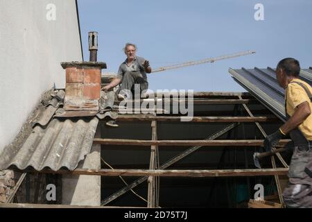 Two workers roofer builder working on roof structure on construction site Stock Photo