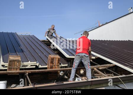 Two workers roofer builder working on roof structure on construction site Stock Photo