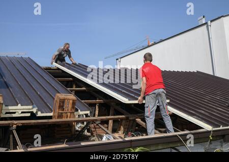 Two workers roofer builder working on roof structure on construction site Stock Photo