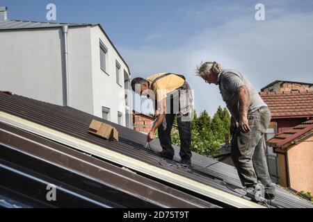 Two workers roofer builder working on roof structure on construction site Stock Photo