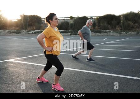 A middle-aged couple are working out on the street Stock Photo