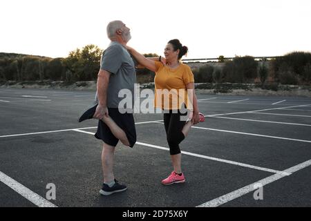 A middle-aged couple are doing stretching exercises together. Stock Photo