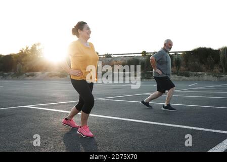 A middle-aged couple are doing exercises with social distance Stock Photo