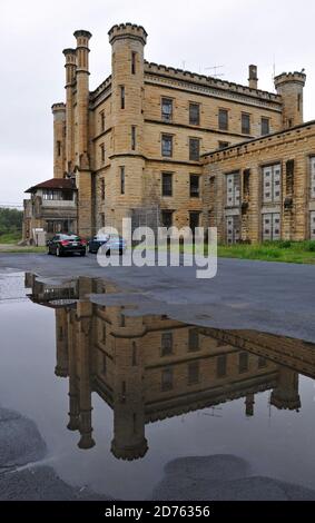 The imposing facade of the Old Joliet Prison is reflected in a puddle. The historic site opened in 1858, operated until 2002 and is now open for tours. Stock Photo
