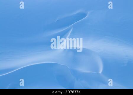 beautiful smooth lines texture of snowdrifts play of light and shadow of a winter landscape on the background Stock Photo