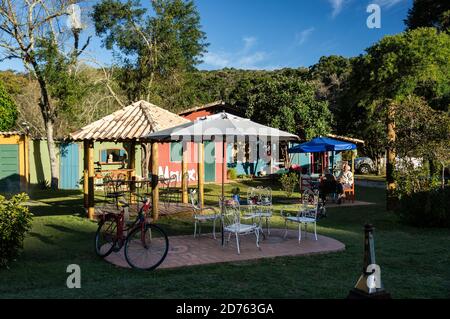 Cozy and beautifully decorated backyard garden of Moara Cafe under late afternoon sun and clouded blue sky. Cunha, Sao Paulo - Brazil. Stock Photo